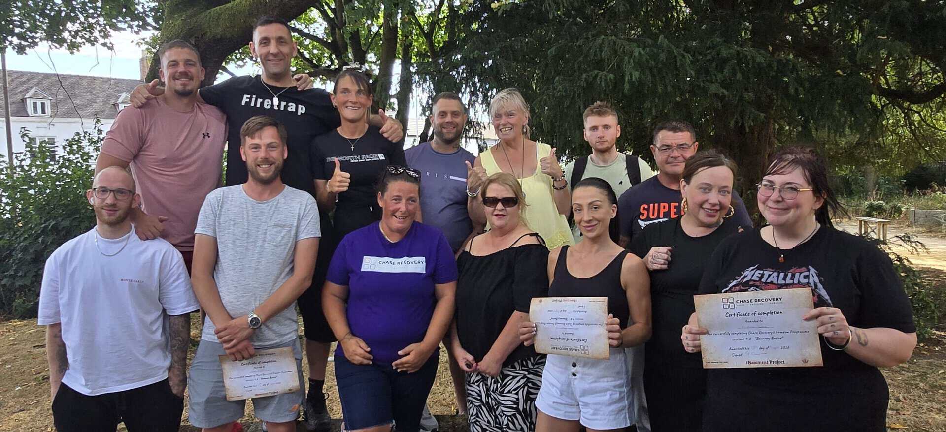 Group of graduates holding certificates at Cannock Freedom event.